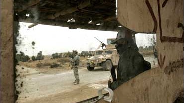 An Iraqi volunteer civilian and a US soldier of 3rd Brigade Combat team, 3rd Infantry Division at a check point in Al-leg 