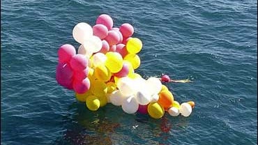 a cluster of colored party balloons floating in the ocean near Florianopolis, in Brazil's southern state of Santa Catarina 