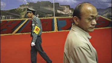 A Chinese security guard and a visitor at an exhibition on Tibet at the Cultural Palace of Nationalities in Beijing 
