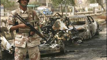 An Iraqi soldier stands guard at the scene where a parked car bomb blew up and hit an Iraqi army patrol in the Zayouna area in Baghdad 
