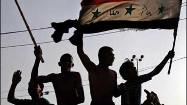 Iraqi soccer fans wave their country's flag as they celebrate Iraq's win over China 