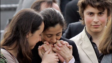 Former hostage Ingrid Betancourt, center, kisses the hands of her daughter Melanie, left, and son Lorenzo upon her children's arrival from France to a military base in Bogota, Thursday, July 3, 2008. Betancourt, three U.S.military contractors and 11 other 