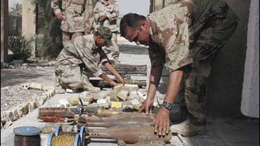 Iraqi army soldiers examine seized weapons at an army base in Baghdad 
