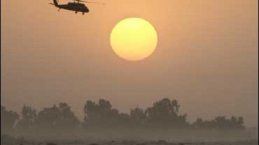 A helicopter flies at sunset near the airport in Baghdad, Iraq 