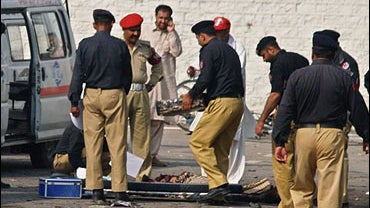 Pakistani security officials examine the site of suicide bombing at a gate of Pakistan's ordinance factory in Wah, a garrison city about 35 kilometers (20 miles) west of the capital Islamabad, Pakistan on Thursday, Aug. 21, 2008. 