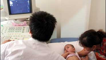 A Chinese doctor examines a baby who was fed with Sanlu milk powder at a hospital in Jinhua city, east China's Zhejiang province 