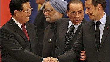 Chinese President Hu Jintao, left, shakes hands with French President Nicolas Sarkozy, right, as Italian Prime Minister Silvio Berlusconi, second from right, interrupts during the opening ceremony for the 7th Asia Europe Meeting held in Beijing, China, Fr 