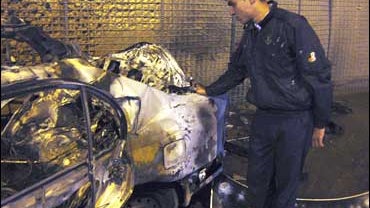An Iraqi policeman examines a car bomb that was detonated by US military bomb technicians before it reached its target in Kirkuk 