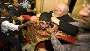 Israeli police scuffle with an Armenian monk next to the place traditionally believed to be the tomb of Jesus Christ at the Church of the Holy Sepulcher 