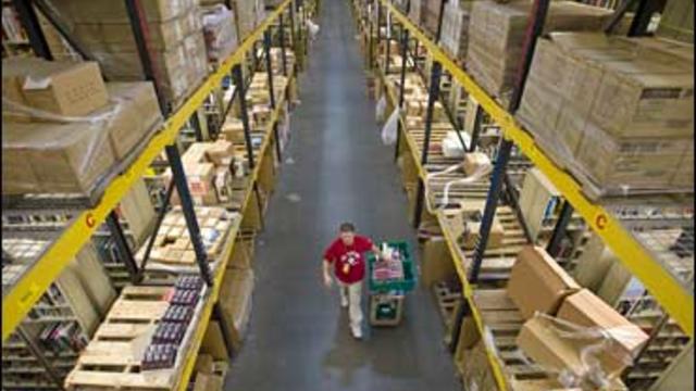 An Amazon.com team member selects merchandise from one of the product isles at their Fernley, Nev., warehouse on Dec., 1, 2008. 