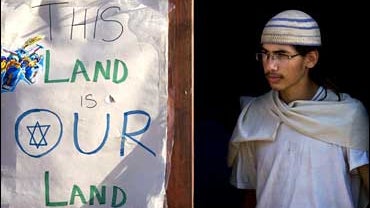 A Jewish settler stands in a doorway next to a sign on a disputed building in the West bank city of Hebron 
