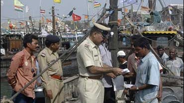 Gujarat state police inspector Subhash Raval, center, inspects the identity cards of fishermen in Porbander, 255 miles west of Ahmadabad, India, on Dec. 2, 2008. Security has been beefed up in coastal towns in the Saurashtra region after terrorists used t 