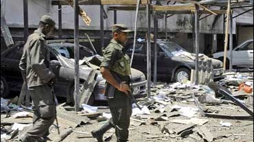 Soldiers look at the damage caused to the building of the Sri Lankan Inland Revenue Department following an attack by Tamil Tiger rebels in Colombo 