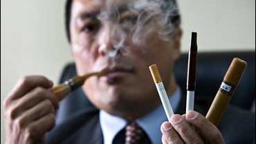 Miao Nan, executive director of Ruyan Group Ltd., puffs an electronic smoke 