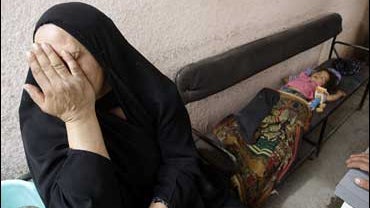 Iman Khalaf, a child who got lost and was found unhurt at the site of a suicide bombing in Baghdad's Kazimiyah neighborhood, sleeps as her grandmother, who had just found her, cries in the Kazimiyah hospital in Baghdad, Iraq 