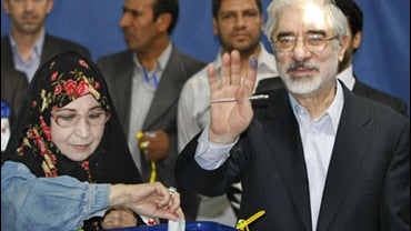 Leading challenger and reformist candidate Mir Hossein Mousavi holds his inked finger aloft after casting his vote with his wife Zahra Rahnavard, left, in the Iranian presidential elections at the Ershad mosque, on the outskirts of Tehran, Iran, Friday, J 