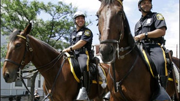 Newark police officer Manuel Spruill, center right, sits on his police horse Saber while on duty with fellow officer Anthony Matos, left, aboard Commander, in Newark, N.J., Tuesday, June 23, 2009. Saber, once a harness racing champion named Broadway Kevin 
