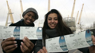 Ayesha Obi, left, and Ava Zadkhorvash pose with the first tickets sold for Michael Jackson's London concert, Friday, March 13, 2009, in front of the O2 Arena. 