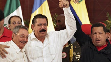 Venezuela's President Hugo Chavez, right, rises the arm of ousted Honduras' President Manuel Zelaya, center, who embraces Cuba's President Raul Castro at the end of the Central American Integration System, or SICA, summit in Managua, Monday, June 29, 2009 