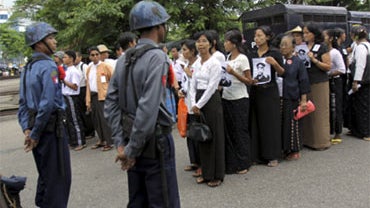 Supporters of pro-democracy leader Aung San Suu Kyi look on just prior to being arrested by Myanmar soldiers following a Martyr's Day ceremony in Yangon Sunday, July 19, 2009. 