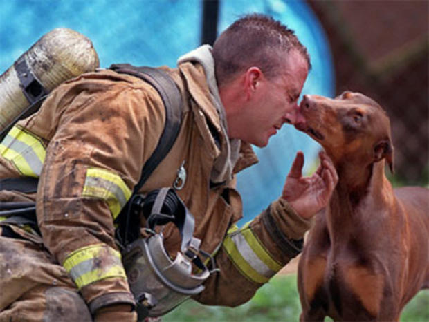 Charlotte firefighter Jeff Clark, from Engine No. 4, gets the lick of love or thanks from a dog he found safe and sound during a house fire Tuesday, July 20, 1999, in Charlotte, N.C. 