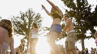 People listen to music as the sun sets at the Bonnaroo music festival in Manchester, Tenn., Saturday, June 14, 2008.