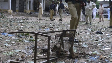 Pakistani police officers and media men gather at the site of suicide bombing in Mingora, the main town of Pakistan's troubled Swat Valley, Sunday, Aug. 30, 2009. 