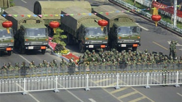 Paramilitary policemen in riot suits stand guarding a blocked road in Urumqi, in western China's Xinjiang region, Friday, Sept. 4, 2009. 