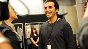 Designer Yigal Azrouel talks backstage before his spring 2010 collection is shown at fashion week in New York, Friday, Sept. 11, 2009. (AP Photo/Diane Bondareff) 