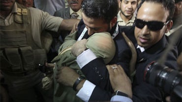 Muntadhar al-Zeidi, center, an Iraqi reporter who threw his shoes at former President George W. Bush, embraces his sister as he arrives at the offices of his employer Baghdadiyah TV after his release from a Baghdad prison Tuesday, Sept. 15, 2009. 