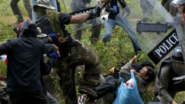 Thai villagers fall on the ground after clashing with protesters, left, as riot police officers try to safe him during a protest against the occupation of land by Cambodian people in Sisaket province, northern Thailand Saturday, Sept. 19, 2009. 