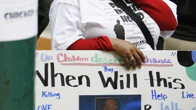 SLIDESHOW - Ava Johnson, mother of Eugene Riley, who has been charged with beating to death 16-year-old Derrion Albert on Sept. 24, talks to the media as she holds her son photo at Fenger High School in Chicago, Monday, Sept. 28, 2009. Johnson said her so 