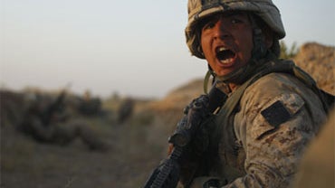 U.S. Marine Lance Cpl. Vincent Morales, of Baytown, Texas, with 3rd Platoon, Bravo Company, 1st Battalion 5th Marines, yells to a fellow Marine inside a dry irrigation canal, in Nawa district, Helmand province, southern Afghanistan, Friday, Oct. 2, 2009. 