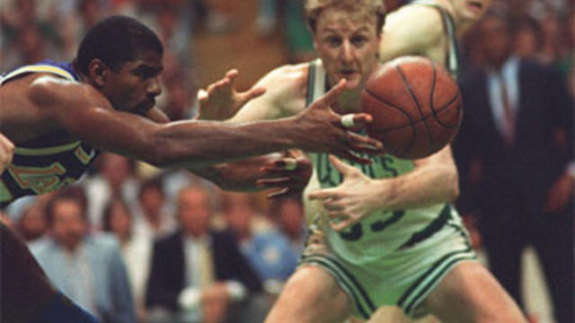 Earvin "Magic" Johnson of the Los Angeles Lakers reaches for a loose ball in front of Larry Bird of the Boston Celtics 