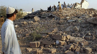 Local residents gather on the rubble of a damaged girls high school, wrecked by suspected militants on early morning on Sunday, Nov. 1, 2009 in Karigar Garhi village near Bara, the main town of Pakistan troubled tribal region Khyber along Afghan border. 