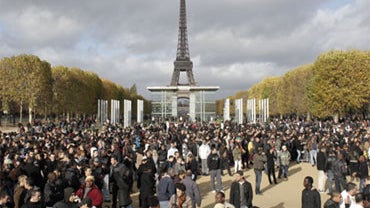 People gather near the Eiffel Tower as they await a money handout, deliver by a French marketing company Mailorama, in Paris, Saturday, Nov. 14, 2009. The crowd has forced the Internet site to cancel the promotional stunt to hand out tens of thousands of  