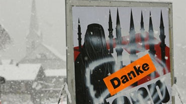 A poster of a conservative initiative promoting the ban of the building of minarets in Switzerland is sprayed with a peace sign and a sticker saying "thank you" in the village of Amsteg in central Switzerland, Monday, Nov. 30, 2009. 