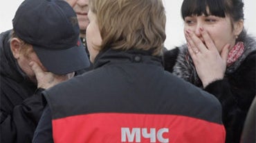 Grieving relatives of victims of a nightclub fire are comforted by an emergency worker at a morgue in Perm, about 700 miles east of Moscow, Saturday, Dec. 5, 2009. 
