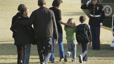 President Barack Obama, third from left, with his family, from left to right: his mother-in-law, Marian Robinson, daughter, Malia, wife Michelle, an unidentified friend and daughter, Sasha, walk on the South Lawn of the White House to board Marine One in  