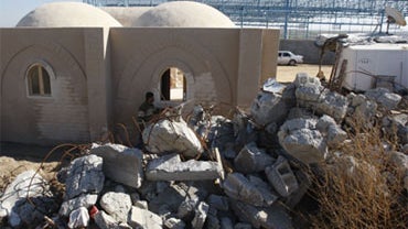 This Dec. 13, 2009 photo shows the Athamneh family house, made of local materials in an ancient technique, compressed mud bricks, wooden window frames and a domed roof that does not require steel, next to a destroyed house in Jebaliya, northern Gaza Strip 