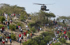People run toward a U.S. helicopter as it makes a water drop near a country club used as a forward operating base for the U.S. 82nd Airborne Division in Port-au-Prince, Haiti, Saturday, Jan. 16, 2010. 
