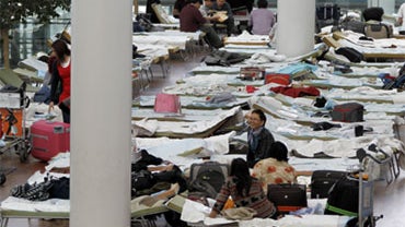Passengers rest on camp beds in a terminal at the airport in Munich, southern Germany, on Saturday, April 17, 2010. 