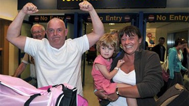 Passenger Chris, his wife Val and their daughter Mia, 4, no family name given, arrive back at Manchester Airport, England from their holiday in Cuba Wednesday April 21, 2010. Britain's Heathrow Airport _ Europe's busiest hub _ has seen the first flight la 