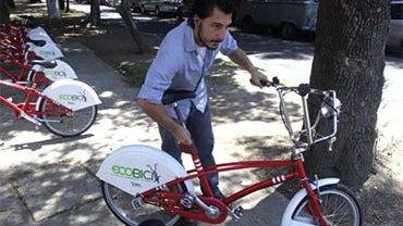 Jose Bracho, 24, adjusts the seat on a bicycle at an "Ecobici" station in Mexico City, Wednesday, April 21, 2010. This spring the city government launched "Ecobici", a bike sharing program, installing 1,100 bikes at 85 stations throughout the downtown are 