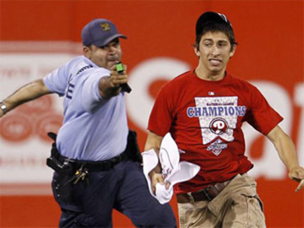 A law enforcement officer chases down a fan who ran onto the field before the eighth inning of a baseball game between the Philadelphia Phillies and the St. Louis Cardinals, Monday, May 3, 2010, in Philadelphia. St. Louis won 6-3. (AP Photo/Matt Slocum) 