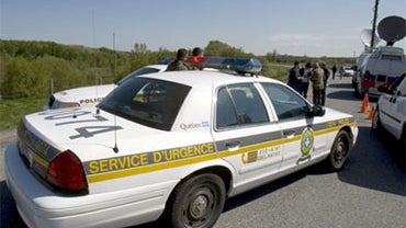 Police block off a road near the scene where a family of four, including two children, is missing after their house was swept away in a landslide Tuesday, May 11, 2010 in St. Jude, Quebec, Canada. (AP Photo/The Canadian Press, Ryan Remiorz) 