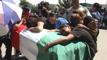 In this April 26, 2010 file photo, relatives of municipal policewoman Anagustina Nevarez Soto grieve over her coffin during a ceremony at the police station in Ciudad Juarez, northern Mexico. Nevarez Soto was killed during an ambush against federal and lo 