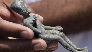 A recently excavated statuette of a boy Pharaoh dating from the 4th or 5th century B.C. is held onboard the Princess Duda research boat, anchored in the harbor of Alexandria, Egypt, Tuesday, May 25, 2010. 