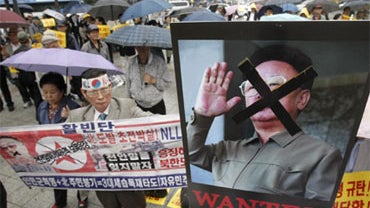 South Korean protesters with a defaced portrait of North Korean leader Kim Jong Il stage a rally against North Korea in Seoul, South Korea, Tuesday, May 25, 2010. 