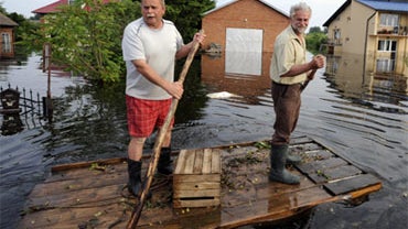 Men on a raft pass by flooded houses in the village of Wilkow southern Poland, Monday, June 7, 2010. A second wave of flooding in a matter of three weeks is hitting Poland after heavy rains in the south. (AP Photo/Alik Keplicz) 